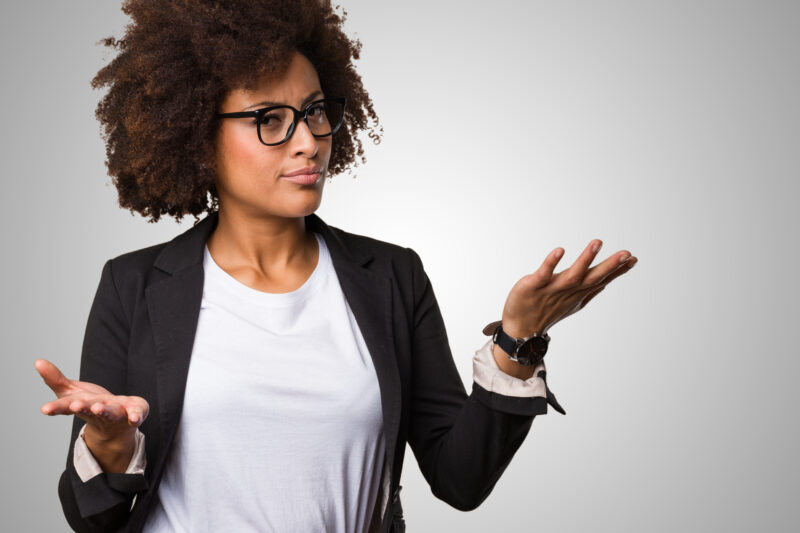 Women looking slightly suspicious while her arms are raised, palms up, in a gesture showing imbalance.