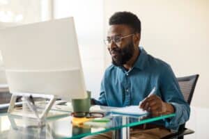 A medical student smiles at his computer as he passes USMLE step 2.