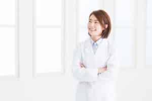 Asian female doctor smiling as she passed the American Board of Internal Medicine board exam.