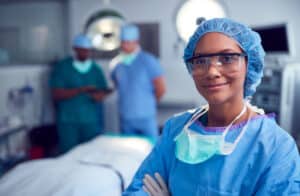 Female surgeon smiles in operating room after passing her ABS Certifying Exam.